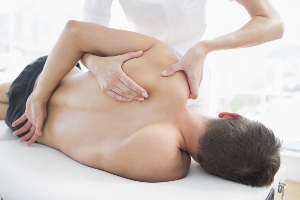 physiotherapist giving shoulder massage