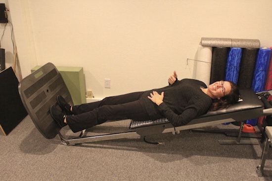woman doing exercises on squat machine