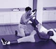 Physical therapist stretching patient's leg