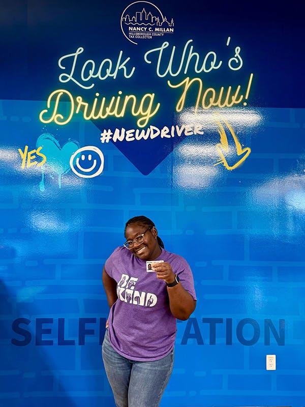 Young lady driver holding up driver's license