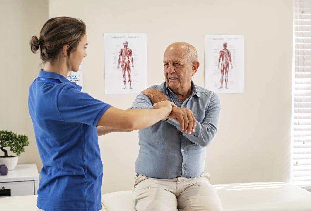 physical therapist evaluating a shoulder patient